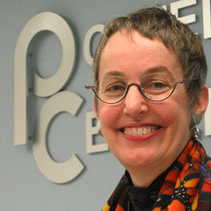 Woman smiling with Postel Center logo in the background